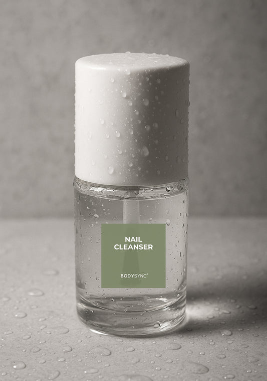 BODYSYNC Nail Cleanser, 15 ml clear bottle with white cap and brush applicator, water droplets on a grey background.
